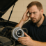 Mechanic inspecting a turbocharger in a diesel engine with a concerned expression.
